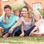 Family Sitting In Garden Together